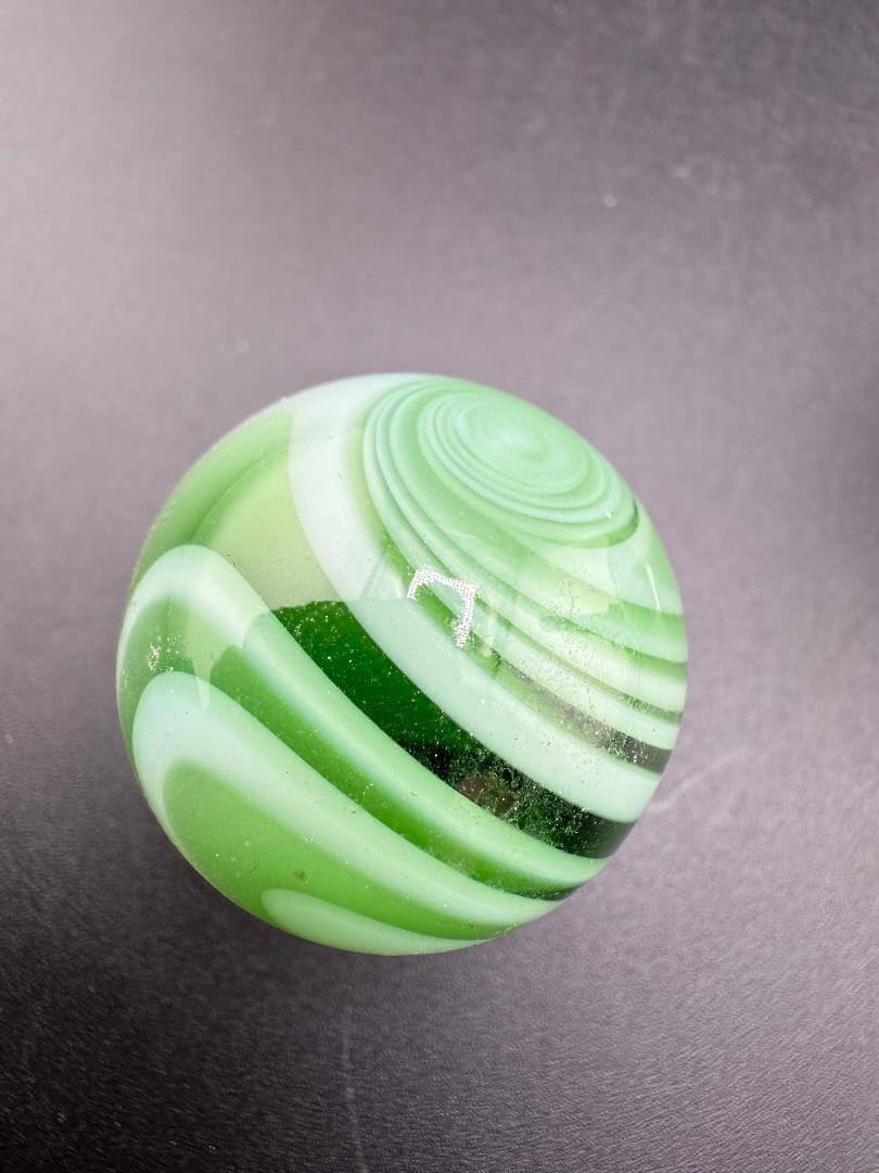 Taco Glass Marble - 2 Tone Spiral 1" with dynamic green spiral design showcasing unique craftsmanship.