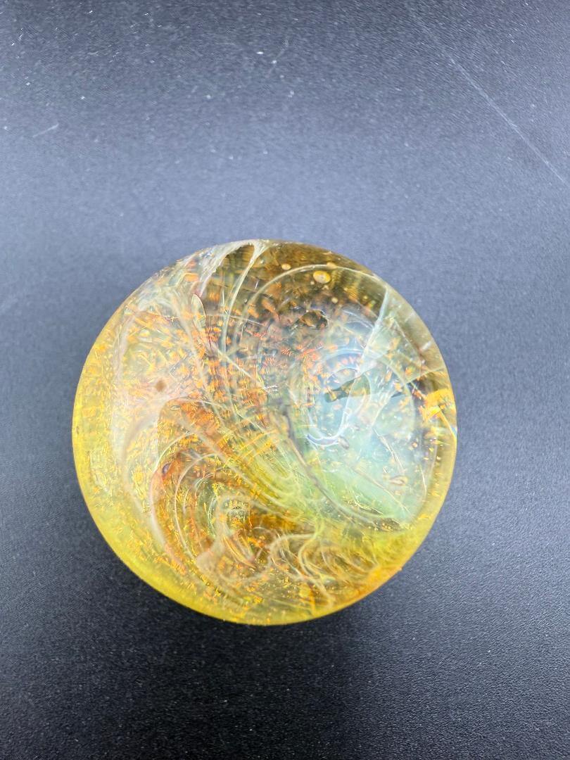 Taco Glass Marble - Fumed Dichro 1.1" showcasing vibrant colors and dichroic finish on a round design.
