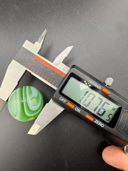 Taco Glass Marble - 2 Tone Spiral 1" measured at 1.076 inches using caliper, showcasing dual-color spiral design.