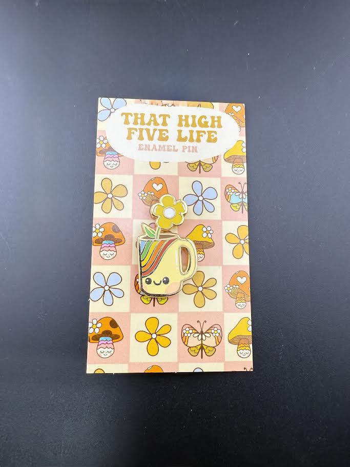 That High Five Life Enamel Pin - Rainbow Mug on a colorful display card with flowers and mushrooms.