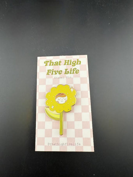 That High Five Life Enamel Pin - Yellow Happy Flower displayed on a checkered card, showcasing its vibrant and cheerful design.