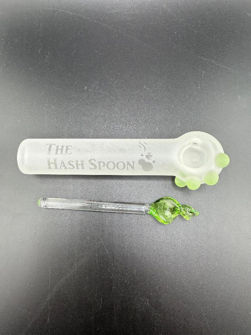 The Hash Spoon glass pipe with green herb, showcasing a unique design ideal for smoking enthusiasts.
