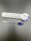 Two glass pipes: a frosted hash spoon with blue details and a sleek clear wand pipe on a black background.