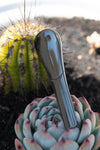 The Journey Pipe J2 placed among succulent plants and a cactus, showcasing its sleek, innovative design.