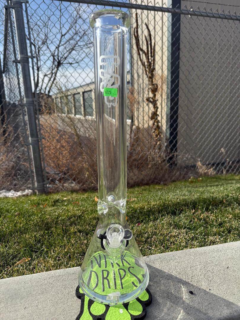 Thick Ass Glass (TAG) Beaker Sandblasted 18" 14mm 45° with a unique design and matte finish on a grassy surface.