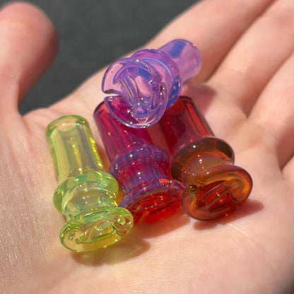 Tokr Glass Puffco Pivot Tip Glass Replacement Mouth Piece in multiple colors on a hand.