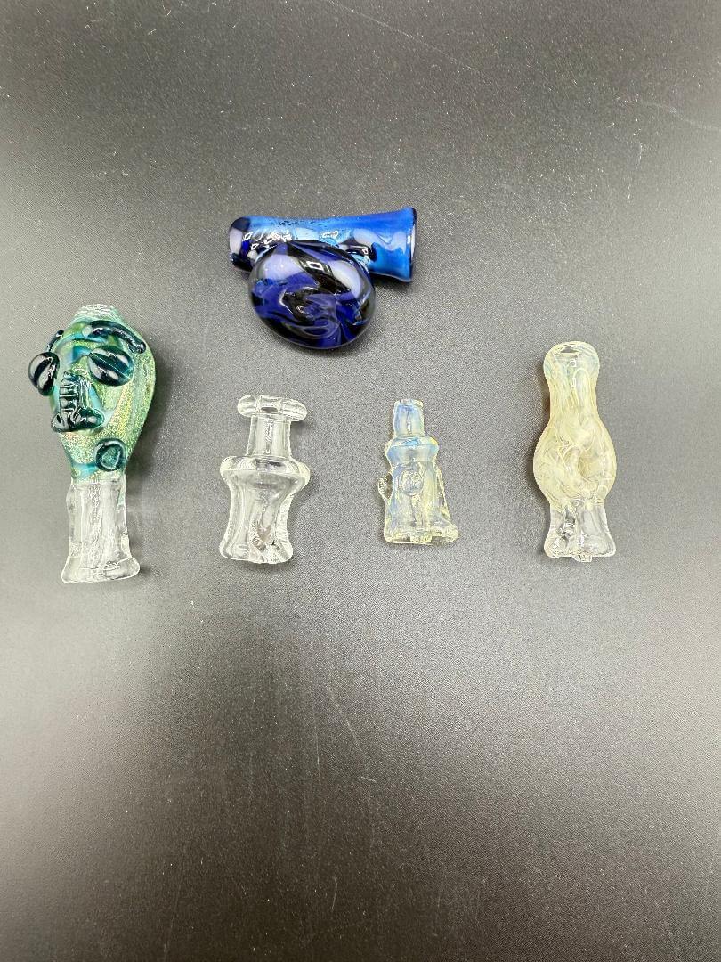 Collection of Tuck Glass Puffco replacement tops showcasing various designs and colors against a black background.
