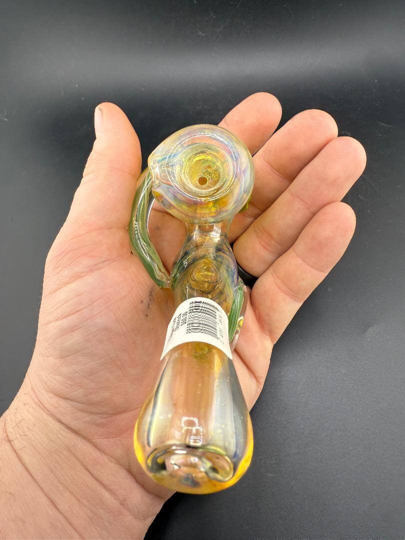 Tuck Glass Sherlock Pipe - Fumed w/ Green Dots held in hand, showcasing its colorful fumed finish and green dot accents.