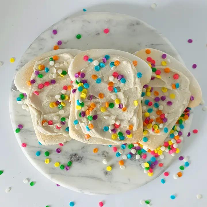 Whipped Up Wonderful Fairy Toast Bubble Bar – delightful bubble dough slices with colorful sprinkles on a marble plate.