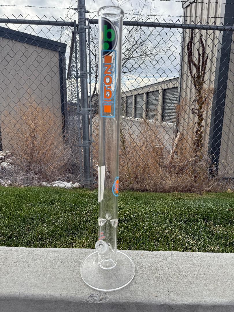 Zob Glass 24" Straight Tube Flower Piece showcased outdoors on grass with a clear background.